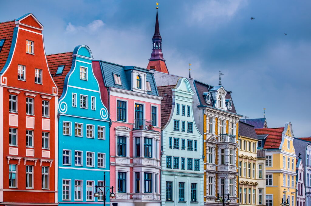Bunte, historische Gebäude mit Kirchturm als Symbol für würdevolle, deutschlandweite Bestattungen von YANA.