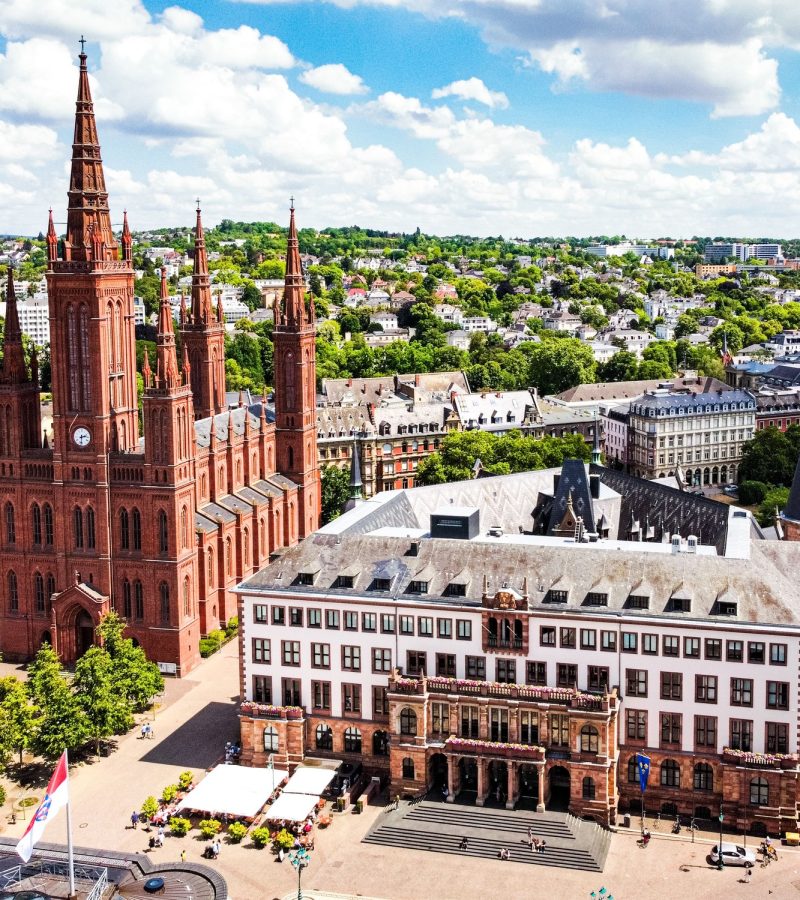 Luftaufnahme einer Kirche und Altbau inmitten grüner Stadt-Symbol für würdige, bezahlbare Bestattungen deutschlandweit.