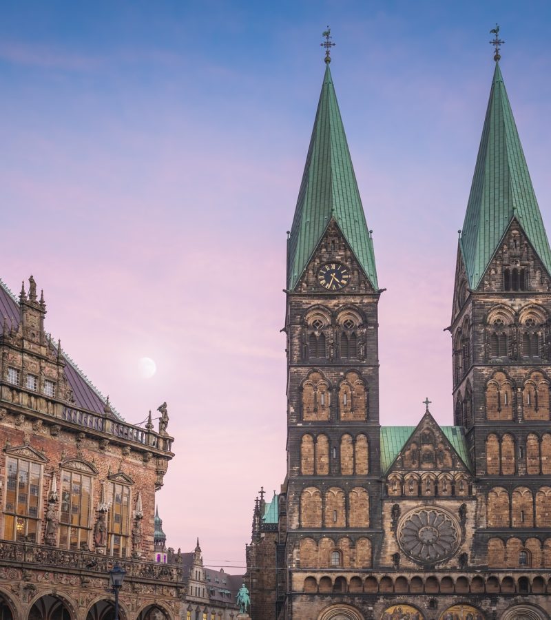 Kathedrale mit grünen Türmen und Mond im Abendhimmel - Symbol für würdevolle Bestattungen in Bremen.