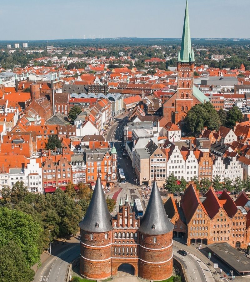 Luftaufnahme von Lübeck mit Holstentor, Symbol für regionale Präsenz und günstige Bestattungen deutschlandweit.