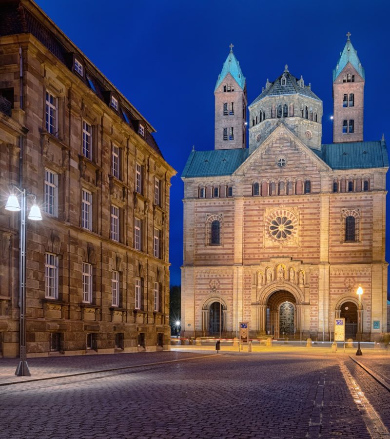 Beleuchtete Kathedrale bei Nacht am Kopfsteinpflaster - Symbol für würdevolle Bestattungen in Deutschland.